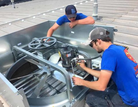 Skilled technicians working on a commercial HVAC unit